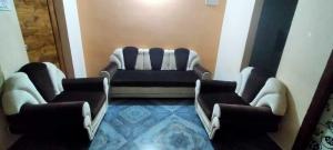 a waiting room with a couch and two chairs at OYO HOME 81185 Srinivas Service Home in Rājahmundry