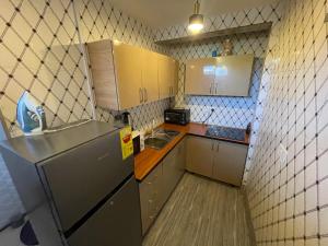 a small kitchen with a sink and a refrigerator at Confortable 2 bedrooms - Center of Osu noble house in Accra