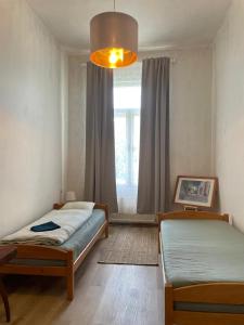 sypialnia z 2 łóżkami pojedynczymi i oknem w obiekcie Hostel Moravia Ostrava w Ostravie