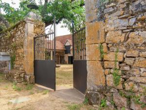 - l'entrée d'un ancien bâtiment en pierre avec un portail dans l'établissement Historic mansion by the River Lot in C nevi res, à Cénevières