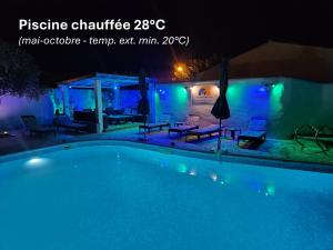 una piscina por la noche con luces azules en La Casa del Arti - Chambres d'hôtes, en Sigean