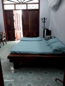 een bed in een kamer met een deur bij Nhà Anh - Sửu in Dien Bien Phu