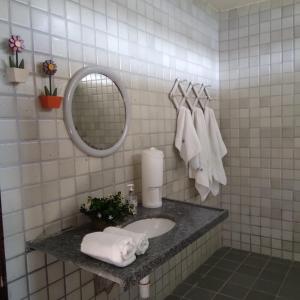 une salle de bain avec un lavabo, un miroir et des serviettes dans l'établissement Casa de Campo em Recife, à Jaboatão dos Guararapes
