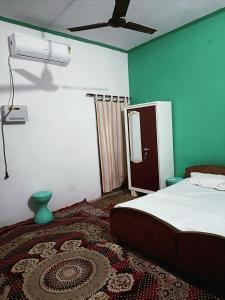 1 dormitorio con 1 cama y ventilador de techo en Gyanbhumi Homestay Ayodhya, en Faizābād