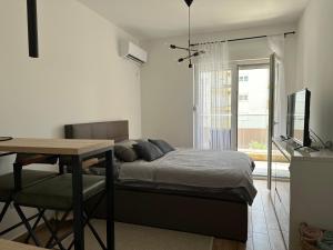 Dormitorio con cama, escritorio y TV en WIN centar apartman, en Trebinje