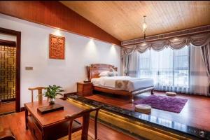 A bed or beds in a room at 阳朔梧桐嘉轩寻龙庭酒店 - 遇龙河夏棠码头店
