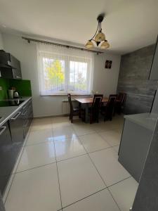 eine Küche und ein Esszimmer mit einem Tisch und Stühlen in der Unterkunft Dom w Zawadzie Lanckorońskiej 101 in Zakliczyn