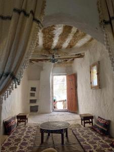 a living room with a table and a window at Gite Douiret in Ad Duwayrāt