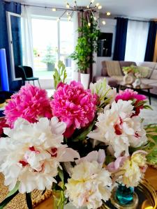 un montón de flores rosas y blancas sobre una mesa en Penthouse View Aeroport Iasi, en Iaşi