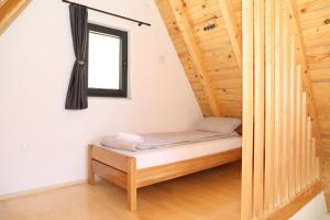 a small bed in a room with a window at Bungalov Mila in Šipovo