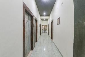 a hallway with white walls and a tile floor at FabHotel Saalt Bandhan Resort in Muzaffarpur