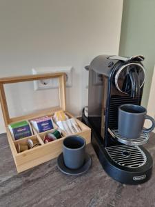 a coffee maker with two cups and a box of tea at Loftfeeling, Parkplatz, WLAN, Diak, Würth in Schwäbisch Hall +10 photos