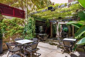 patio ze stołami, krzesłami i winoroślą w obiekcie Hotel Ronda Lesseps w Barcelonie