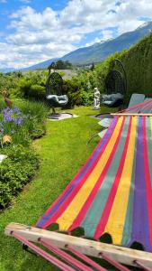 インスブルックにあるGästehaus Alpenblickの芝生の上に並ぶ色彩豊かな縞模様のテーブルと椅子