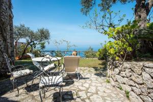 un tavolo e sedie seduti su un patio in pietra di La Cisterna, not only landscape ad Anacapri