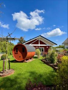a house with a wooden hobbit house in the yard at Ferienhaus Deine Zeit mit SAUNA und WALLBOX in Nettersheim
