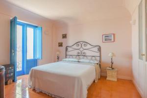 una camera da letto con un grande letto bianco in una stanza di La Cisterna, not only landscape ad Anacapri