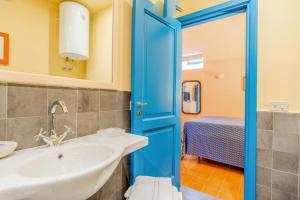 bagno con lavandino e porta blu di La Cisterna, not only landscape ad Anacapri