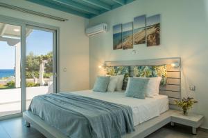 a bedroom with a bed with a view of the ocean at Paradisos in Frangokastello