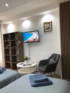 a room with a bed and a tv on a wall at Apartment Mesic is 200 m away from the international airport in Sarajevo in Sarajevo