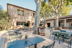 a patio with tables and chairs in front of a building at Domaine de Panery in Pouzilhac
