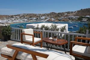 a balcony with chairs and a table and a view of a harbor at Ornos Vibes 1 in Mikonos