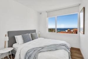 ein weißes Schlafzimmer mit einem Bett und einem Fenster in der Unterkunft Endless Views by Sydney Dreams with Parking in Sydney + 15 Fotos