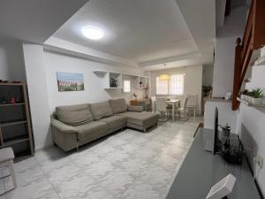 salon z kanapą i stołem w obiekcie Casa adosada junto a la playa de El Perelló w mieście Sueca