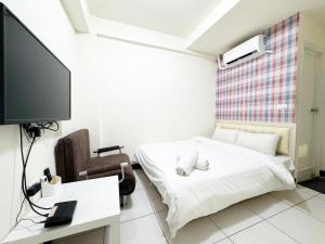 um quarto com uma cama e uma televisão de ecrã plano em Day Day Fengjia em Taichung