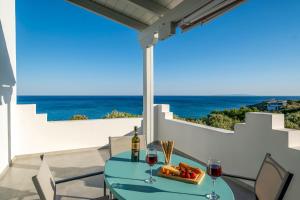 a table with wine glasses and a tray of food on a balcony at Paradisos in Frangokastello