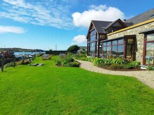 una casa con un césped verde delante de ella en Inishbofin House Hotel, en Inishbofin