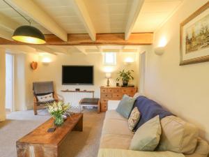 a living room with a couch and a tv at Whincroft in Tavistock