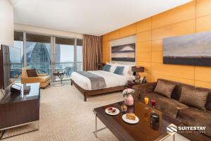 a hotel room with a bed and a couch at OSTAY -Address Dubai Mall - The Residence in Dubai