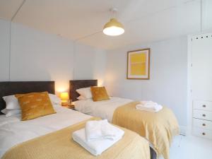 two beds in a room with white walls at Whincroft in Tavistock