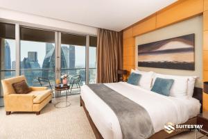 ドバイにあるOSTAY -Address Dubai Mall - The Residenceの大きなベッドと椅子が備わるホテルルームです。