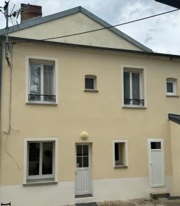 a yellow house with white doors and windows at La petite maison de la gare in Nemours