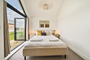 ein Schlafzimmer mit einem Bett und einem großen Fenster in der Unterkunft Acorn House in Dorchester + 48 Fotos