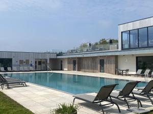ein Swimmingpool mit Stühlen und einem Gebäude in der Unterkunft Acorn House in Dorchester