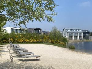 eine Reihe von Bänken am Strand neben einem Gebäude in der Unterkunft Acorn House in Dorchester