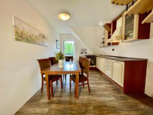 a kitchen with a table and chairs in a room at Mezonet Tatry in Štôla