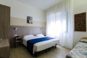 Un dormitorio con una cama grande y una ventana en Hotel Mare Live, en Lido di Jesolo