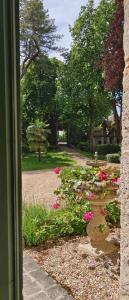 貝萊姆的住宿－Chateau de la Grand'Maison，从带粉红色花卉的花园窗户欣赏美景