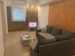 sala de estar con sofá y TV en VELOS en Ledine