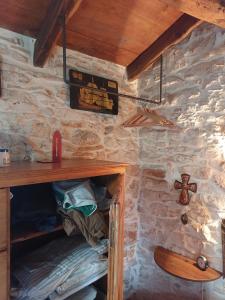 Cottage Casa Vinela في بوجي: غرفة مع رف خشبي وطاولة خشبية