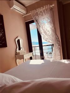 a bedroom with a bed and a window at Hotel Lungomare in Vlorë
