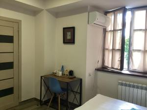 um quarto com uma mesa, uma cadeira e uma janela em Blur Inn Gallery em Yerevan