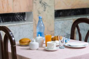 チュニスにあるHôtel le passageのピンクのテーブルクロスと食べ物と飲み物