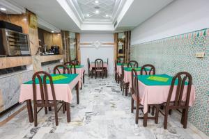um restaurante com mesas e cadeiras rosa e verde em Hôtel le passage em Tunes