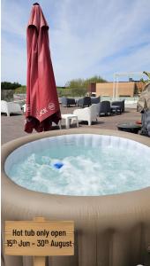 a hot tub only open with a red umbrella at Atlantic Spot Guest House in Praia de Mira