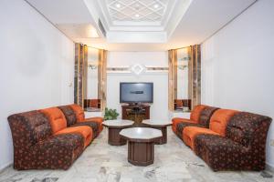 Hôtel le passage في تونس: غرفة معيشة مع كنبتين وتلفزيون